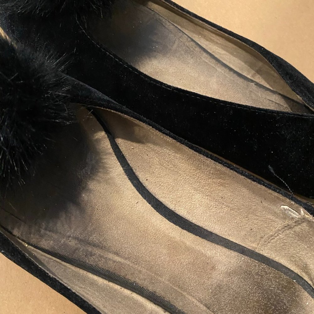 Well worn black ballet flats with poof